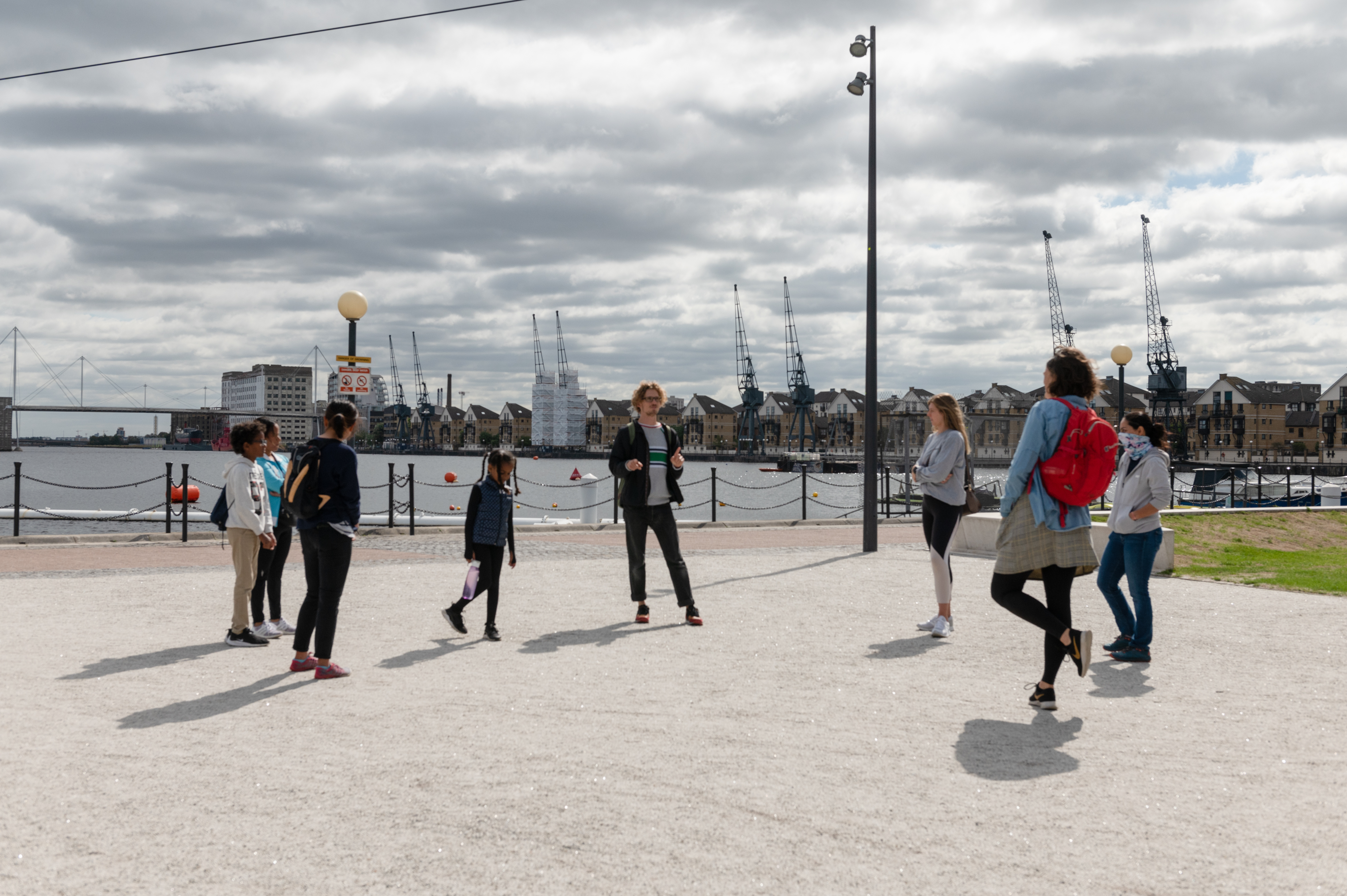 People in a circle next to Royal Victoria Dock
