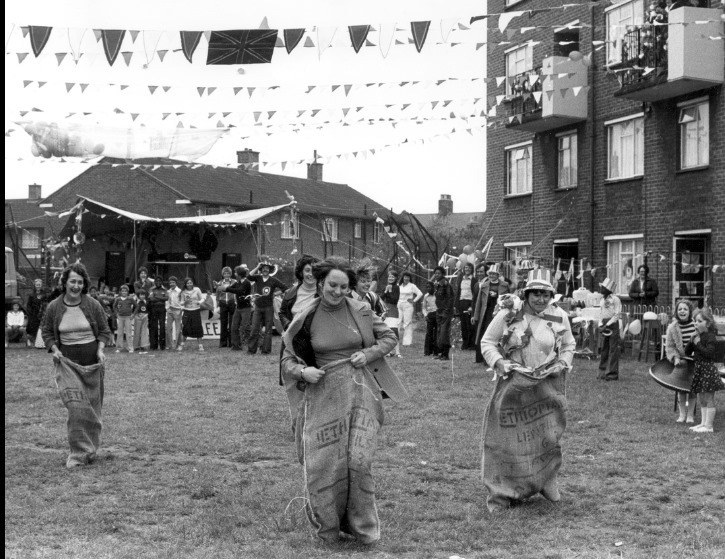 women participating in sack race with bunting overhead