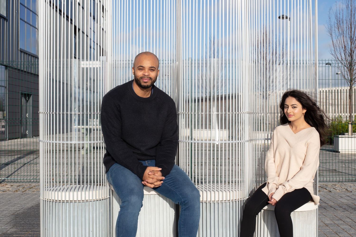 Man and woman sitting on translucent bench