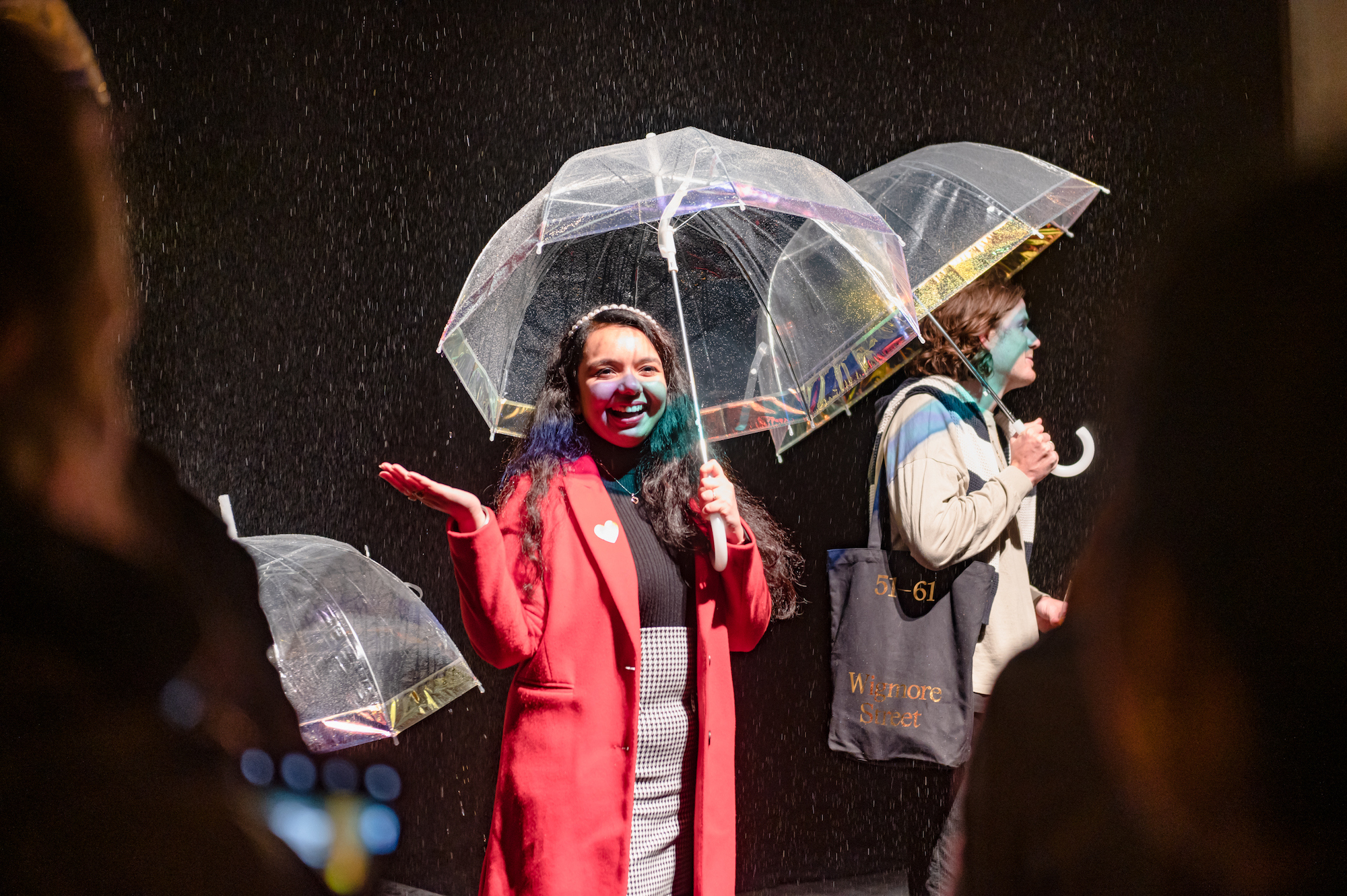 Woman in red coat under an umbrella in the flavour rainbow