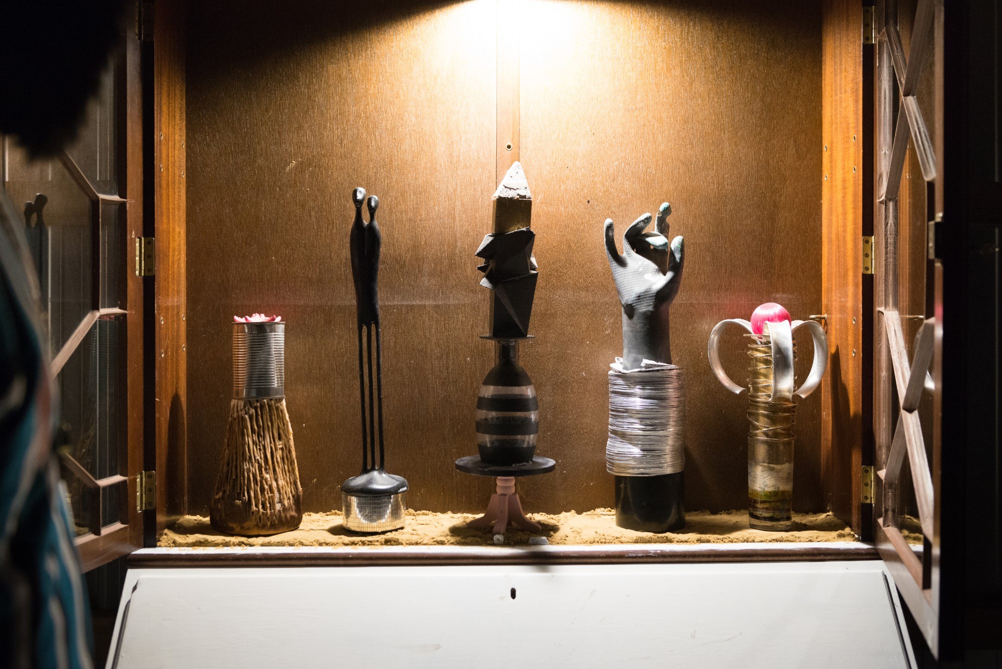 A trophy case with unusually shaped trophies inside, such as a hand and a tin can