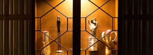 A trophy case with unusually shaped trophies inside, such as a hand and a tin can