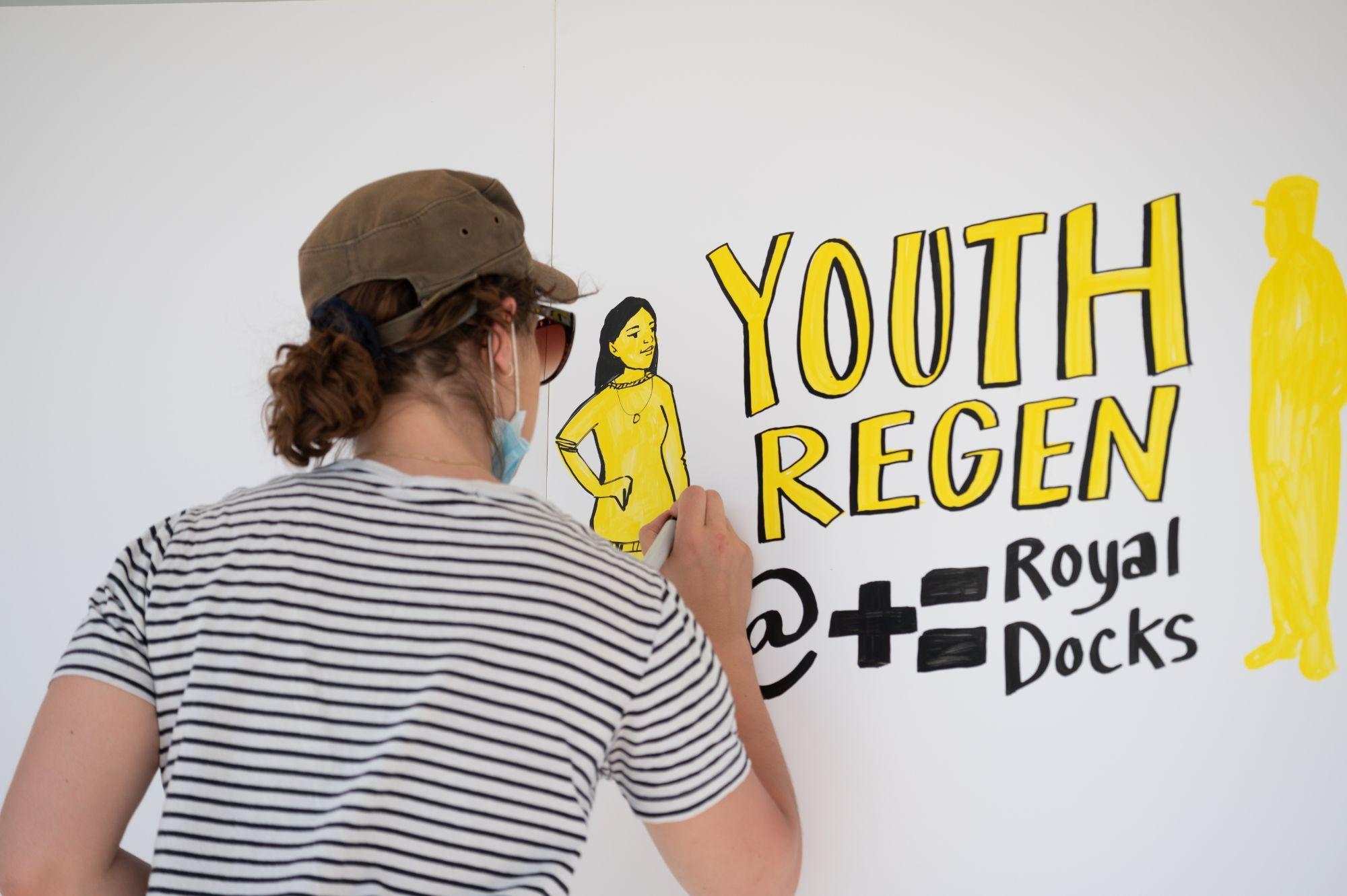 Person in striped top writing on board during workshop