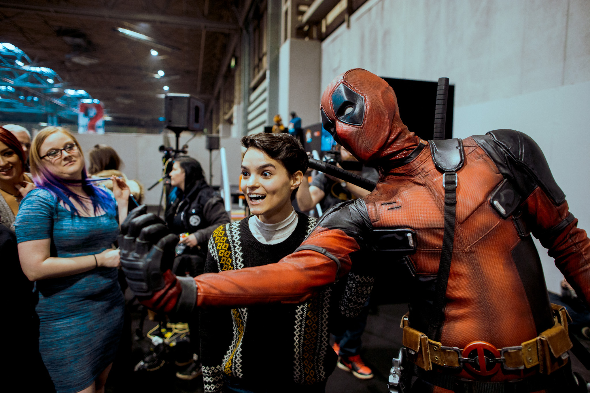 Attendees at Comic Con taking a photo with Deadpool