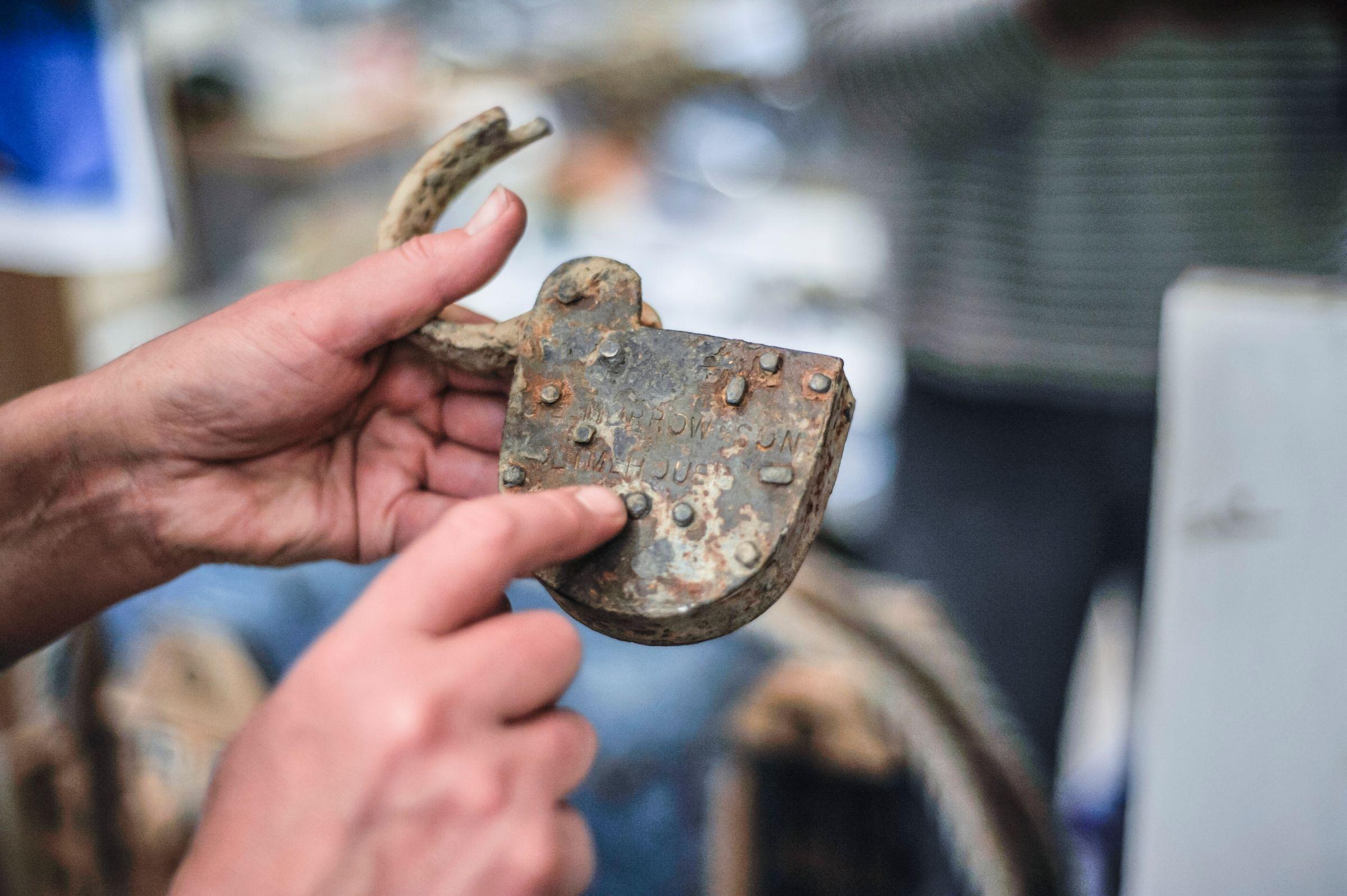 A man holding a rusted padlock