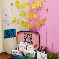 A display for Queer Zine Library in a suitcase