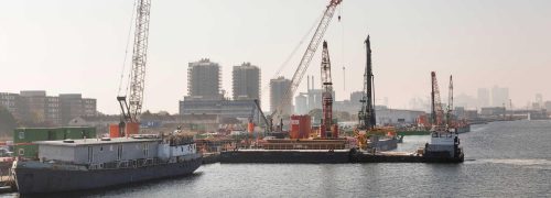 Construction cranes along the edge of the water